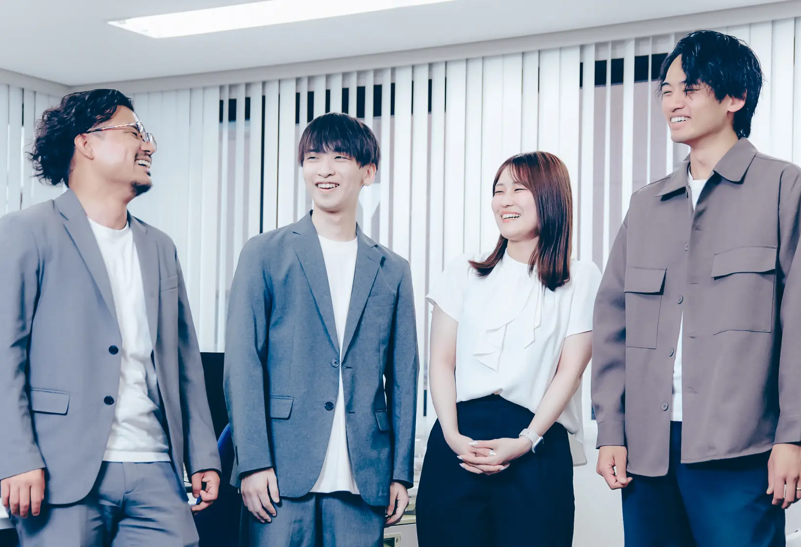 オフィスで談笑する4人の社員