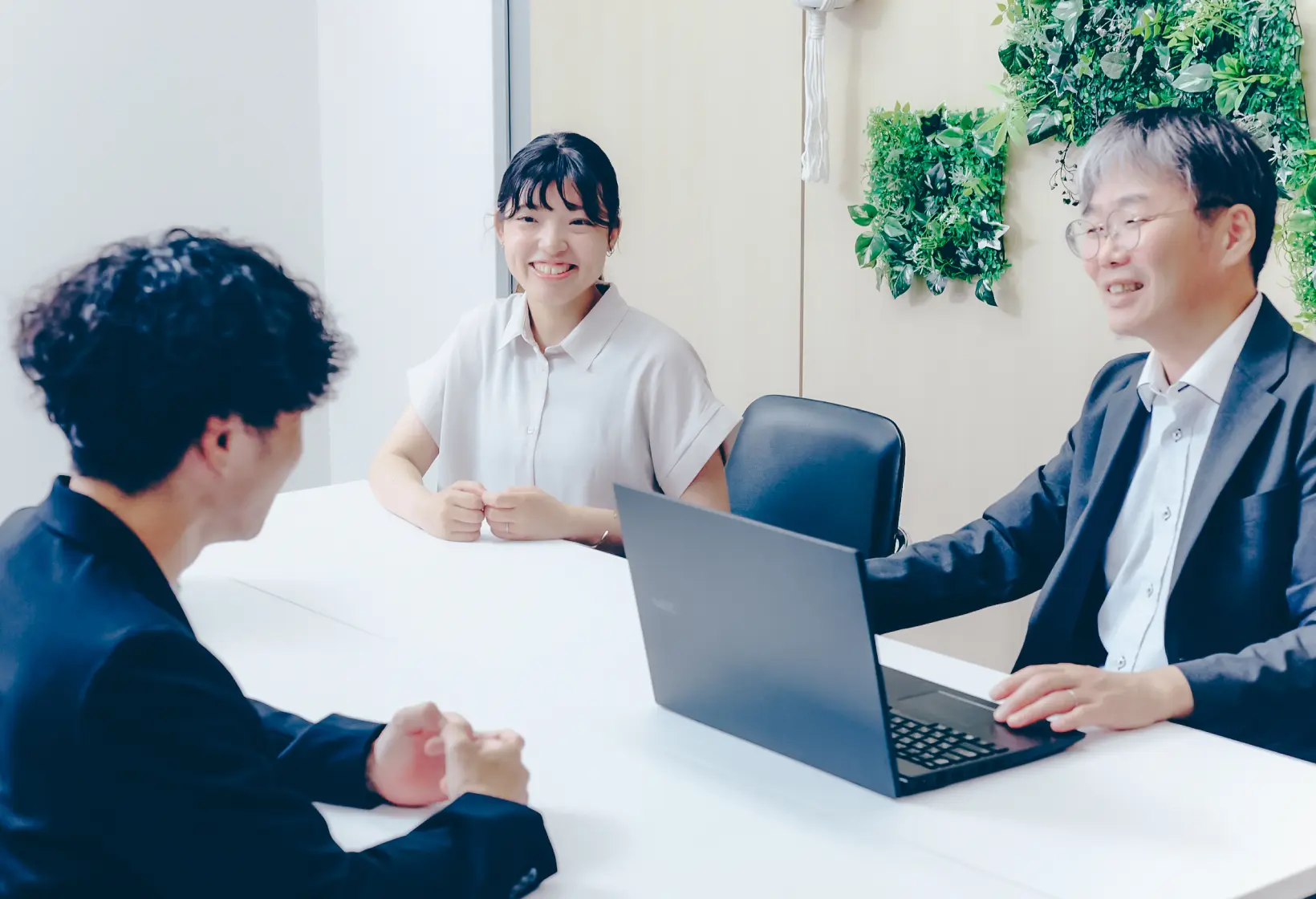 打ち合わせ中の笑顔の女性社員と社員たち
