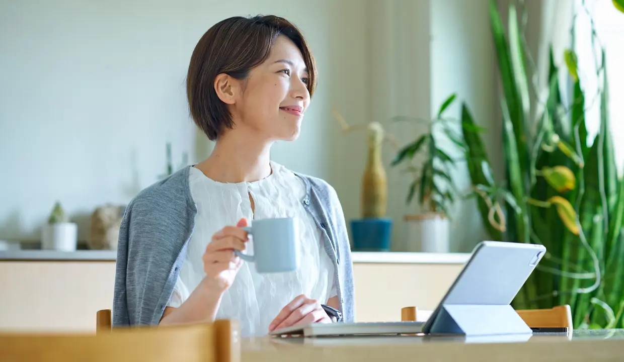 自宅でタブレットを見ながらくつろぐ女性社員