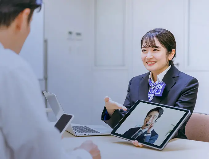 タブレットのビデオ通話でオンライン相談窓口業務に対応する受付担当者
