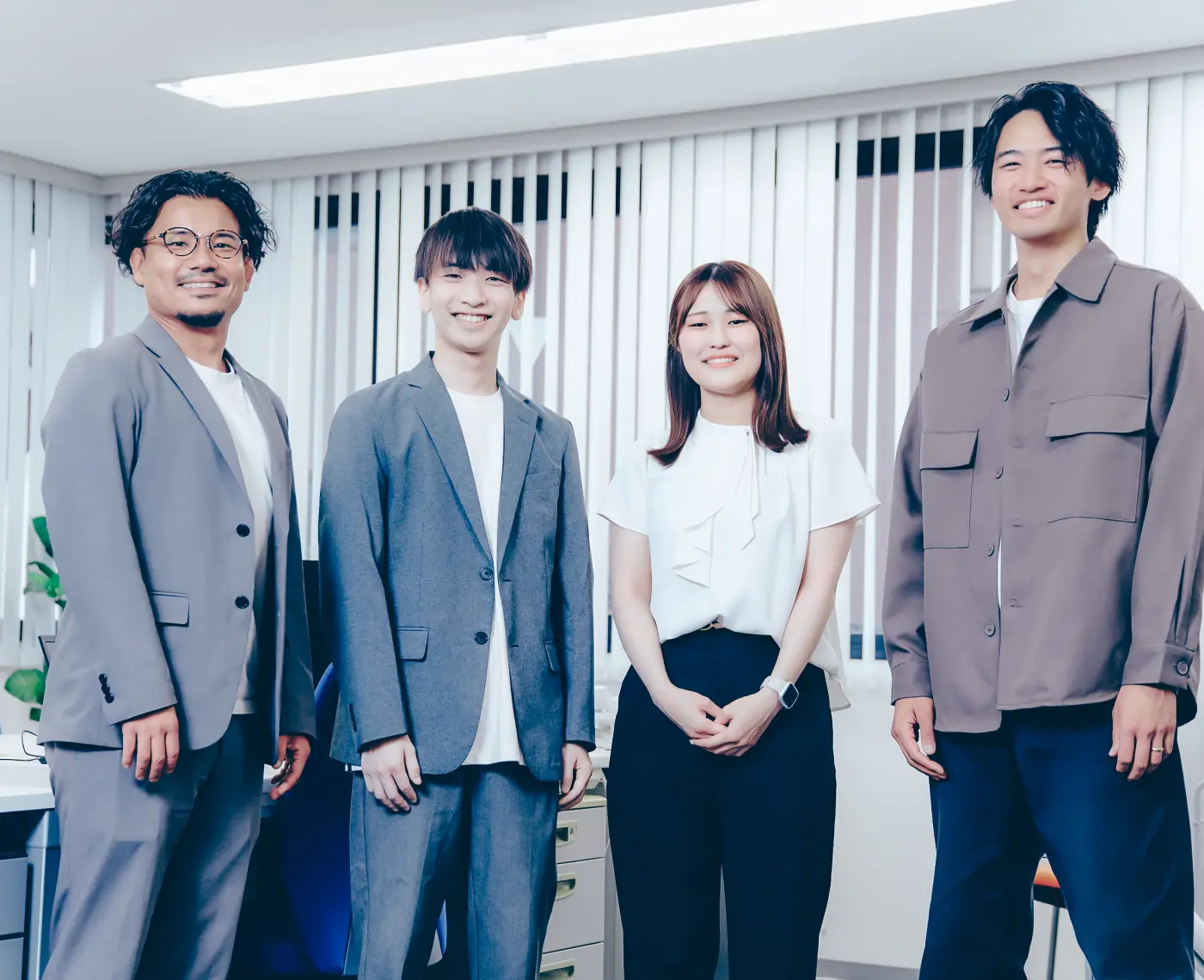 窓際で打ち合わせをする3人のビジネスパーソン