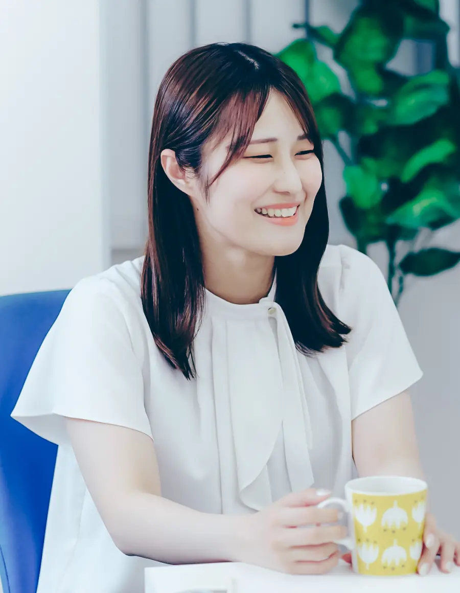 白いブラウスを着た笑顔の女性社員