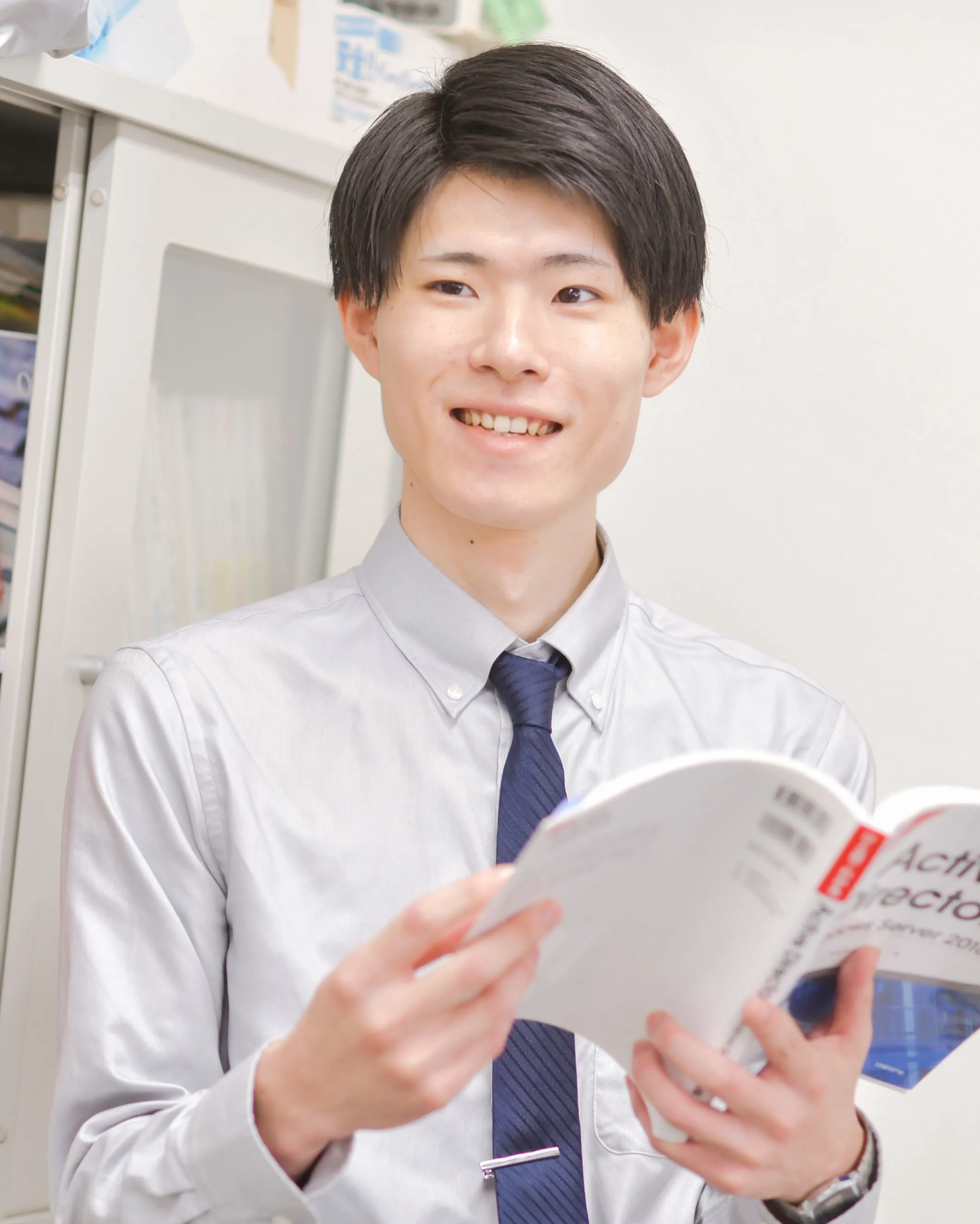 グレーのシャツを着た笑顔の男性社員
